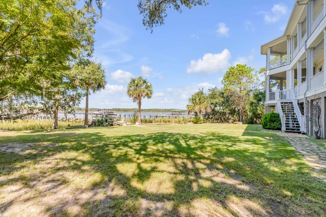 view of yard with a balcony and a water view