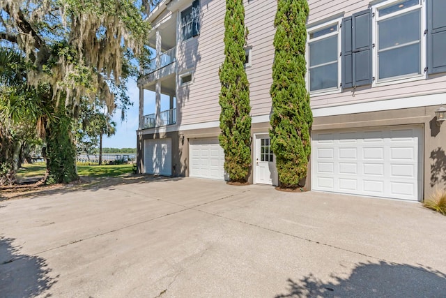 view of side of property featuring a balcony and a garage