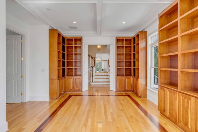 interior space with ornamental molding, light hardwood / wood-style floors, beamed ceiling, and a healthy amount of sunlight