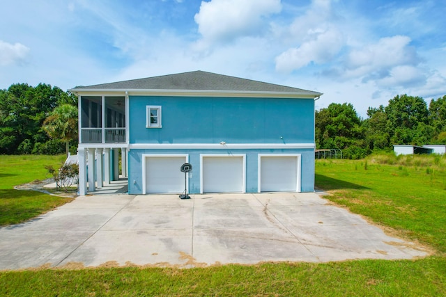 view of side of property featuring a lawn, a sunroom, and a garage