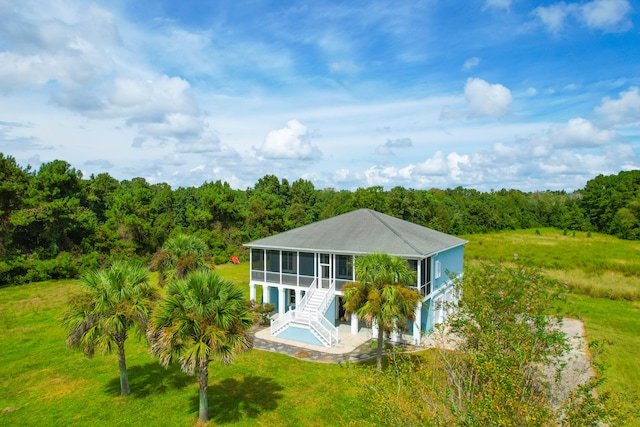 back of property featuring a sunroom, a patio, and a yard