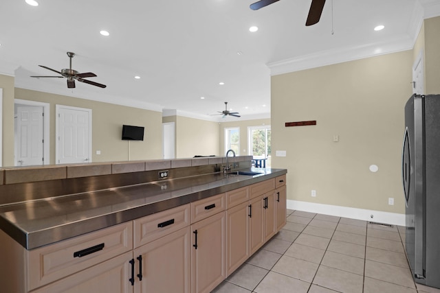 kitchen featuring sink, light tile patterned floors, ornamental molding, ceiling fan, and stainless steel fridge