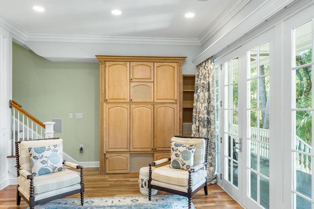 living area with baseboards, ornamental molding, recessed lighting, and light wood-style floors