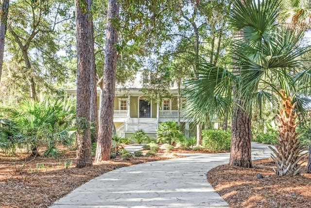 exterior space featuring driveway, stairway, and a porch