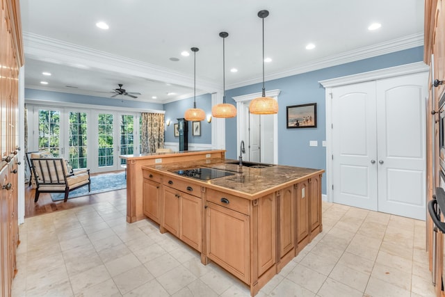 kitchen with pendant lighting, crown molding, a sink, an island with sink, and black electric cooktop