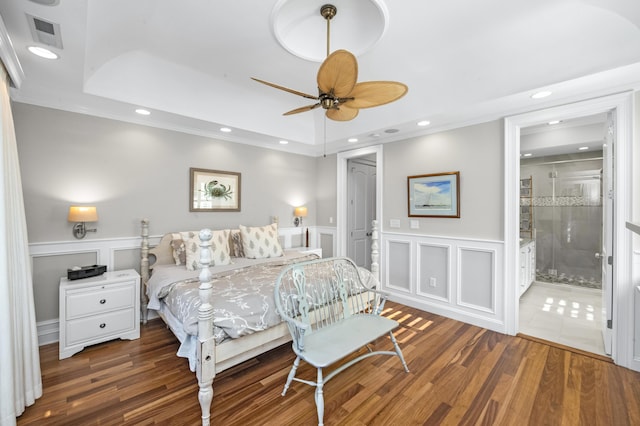 bedroom with visible vents, a decorative wall, and dark wood-style flooring