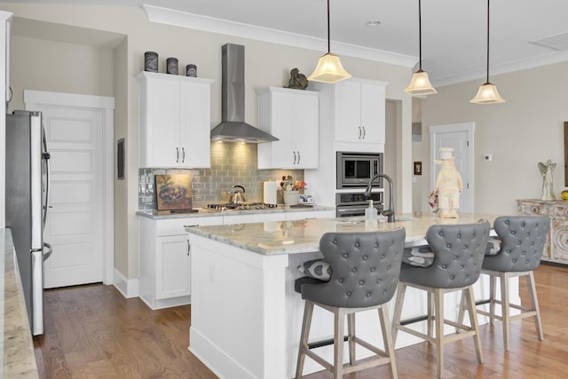 345 Turnstone St, Mount Pleasant, SC 29464 - kitchen with backsplash, wood finished floors, stainless steel appliances, wall chimney range hood, and white cabinets