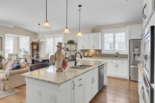 345 Turnstone St, Mount Pleasant, SC 29464 - kitchen with open floor plan, white cabinetry, backsplash, a sink, and appliances with stainless steel finishes
