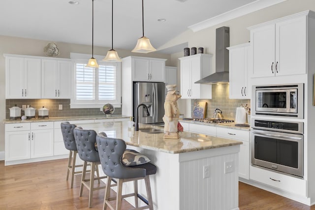 345 Turnstone St, Mount Pleasant, SC 29464 - kitchen featuring a sink, a kitchen bar, a center island with sink, stainless steel appliances, and wall chimney range hood