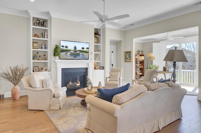345 Turnstone St, Mount Pleasant, SC 29464 - living area with a fireplace with flush hearth, ceiling fan, wood finished floors, built in shelves, and ornamental molding