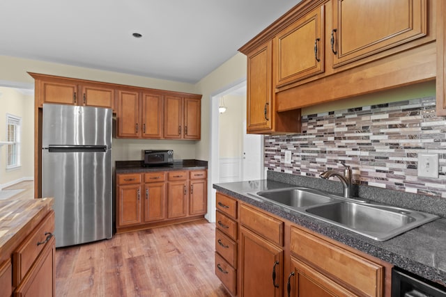 331 Kinard St, Orangeburg, SC 29118 - kitchen featuring freestanding refrigerator, brown cabinets, light wood-style flooring, and backsplash