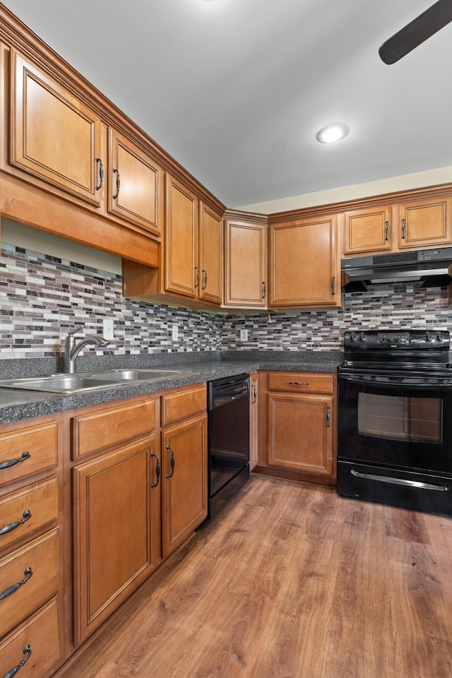 331 Kinard St, Orangeburg, SC 29118 - kitchen with black appliances, ventilation hood, light wood-type flooring, decorative backsplash, and dark countertops