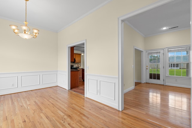 331 Kinard St, Orangeburg, SC 29118 - unfurnished dining area featuring crown molding, a chandelier, light wood finished floors, and wainscoting