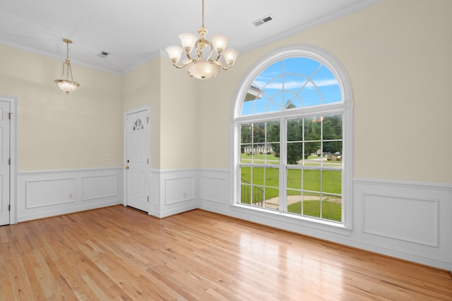 331 Kinard St, Orangeburg, SC 29118 - empty room with a chandelier, ornamental molding, a wainscoted wall, and light wood finished floors