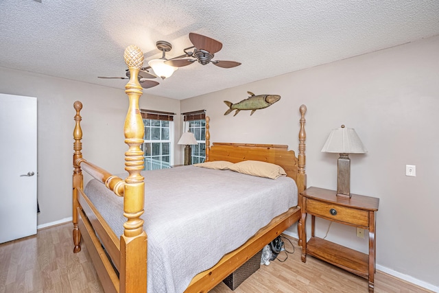 bedroom featuring ceiling fan, a textured ceiling, and wood-type flooring