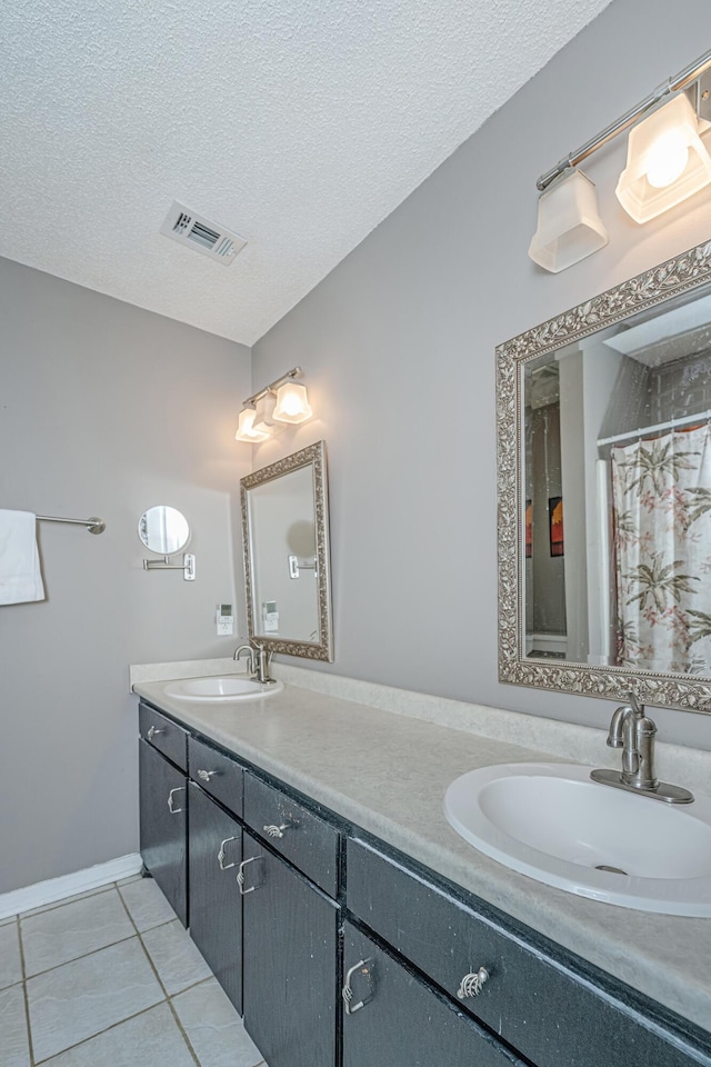 bathroom featuring a textured ceiling, tile patterned flooring, and vanity