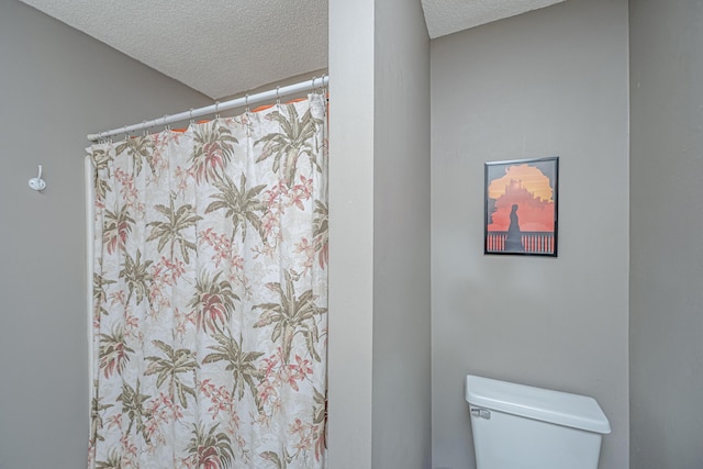 bathroom with toilet and a textured ceiling