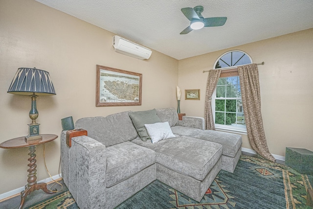 living room featuring a textured ceiling, a wall unit AC, and ceiling fan