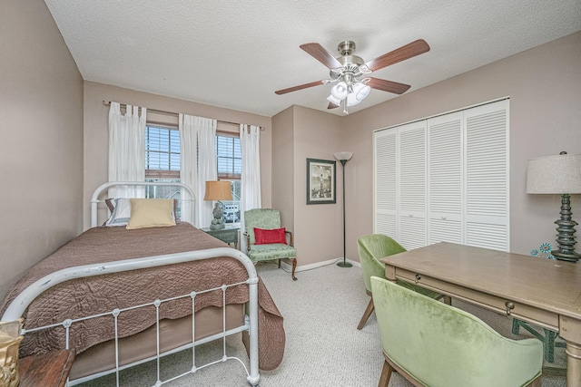 bedroom with a textured ceiling, ceiling fan, and a closet