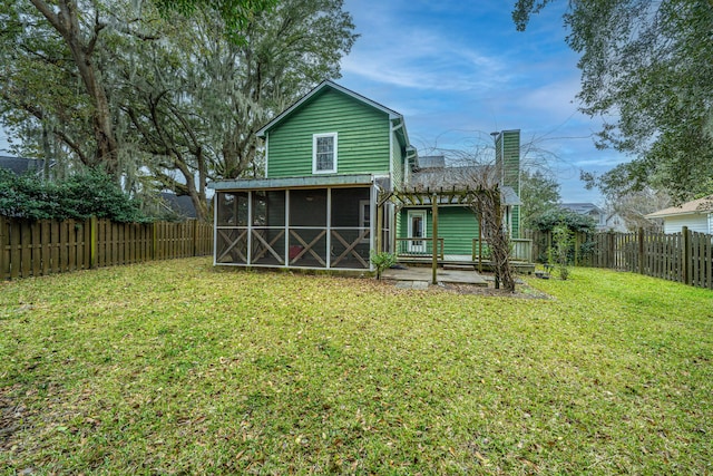 rear view of property featuring a yard, a sunroom, and a pergola