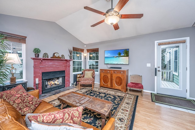 living room featuring ceiling fan, light hardwood / wood-style flooring, lofted ceiling, and plenty of natural light