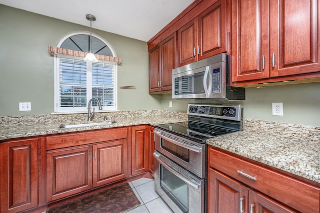 kitchen with stainless steel appliances, hanging light fixtures, light stone countertops, light tile patterned floors, and sink