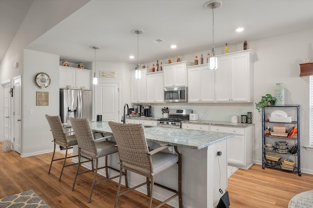 kitchen with white cabinets, an island with sink, and appliances with stainless steel finishes