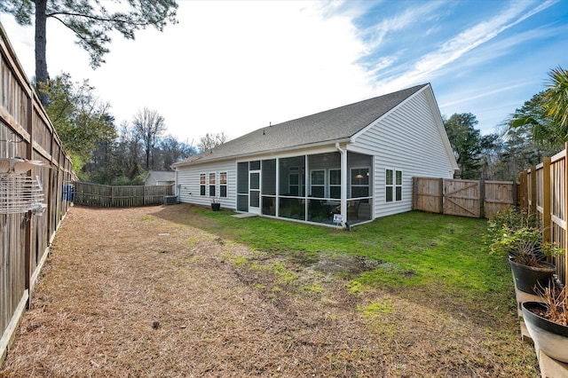 back of house with a yard and a sunroom