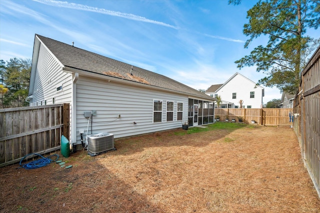 back of house with central air condition unit and a lawn