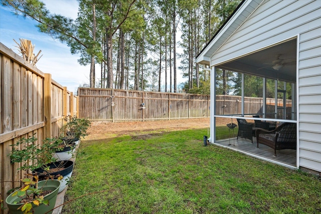 view of yard featuring ceiling fan and a sunroom