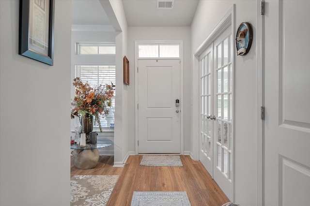 foyer entrance featuring french doors and light hardwood / wood-style flooring