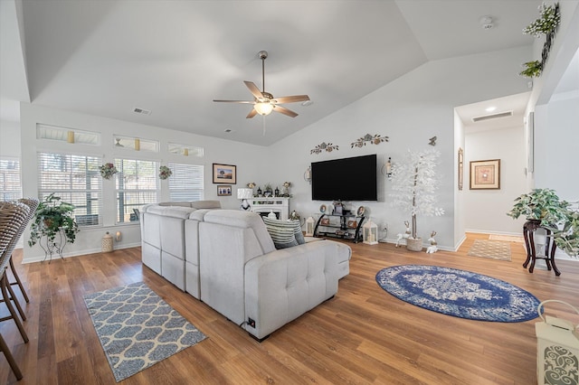 living room with ceiling fan, lofted ceiling, a fireplace, and hardwood / wood-style flooring