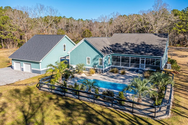 back of house with a sunroom and a lawn