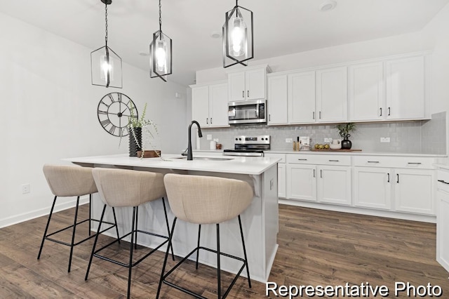 kitchen featuring tasteful backsplash, a sink, stainless steel appliances, and dark wood-style flooring