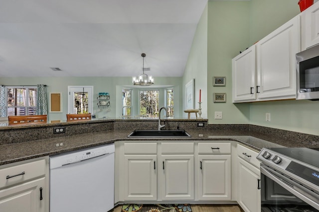 kitchen with stainless steel appliances, white cabinets, an inviting chandelier, and sink