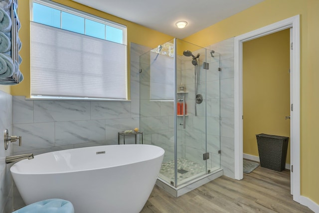 bathroom featuring wood-type flooring and shower with separate bathtub