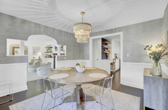 dining room with wallpapered walls and a wainscoted wall