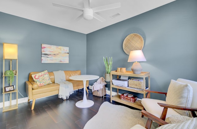 living area featuring baseboards, ceiling fan, visible vents, and wood finished floors