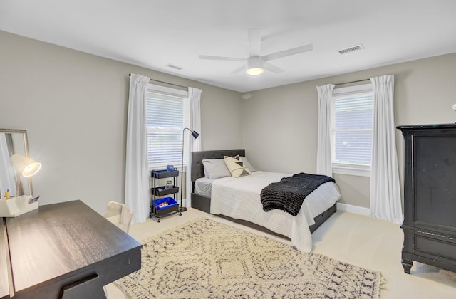 carpeted bedroom with visible vents, a ceiling fan, and multiple windows
