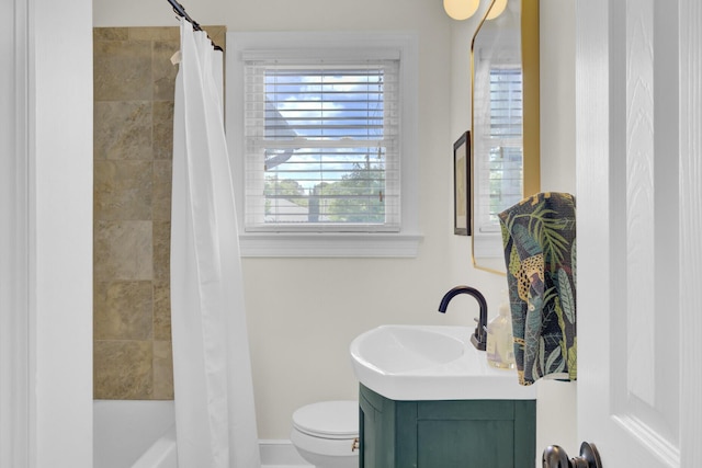 bathroom with vanity, baseboards, shower / bath combo with shower curtain, and toilet