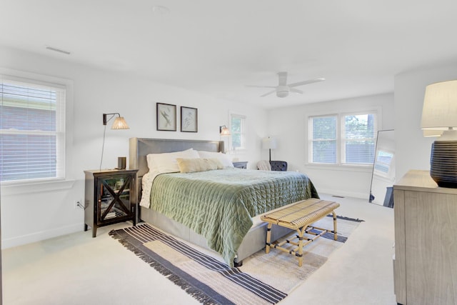 carpeted bedroom with baseboards, ceiling fan, and visible vents