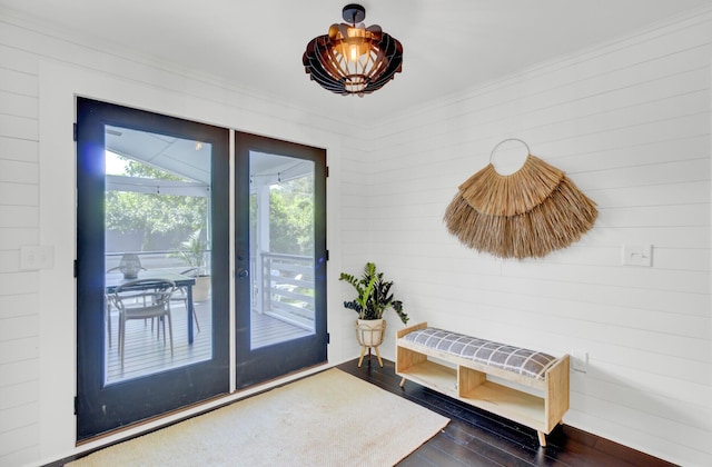 doorway featuring ornamental molding and dark wood finished floors