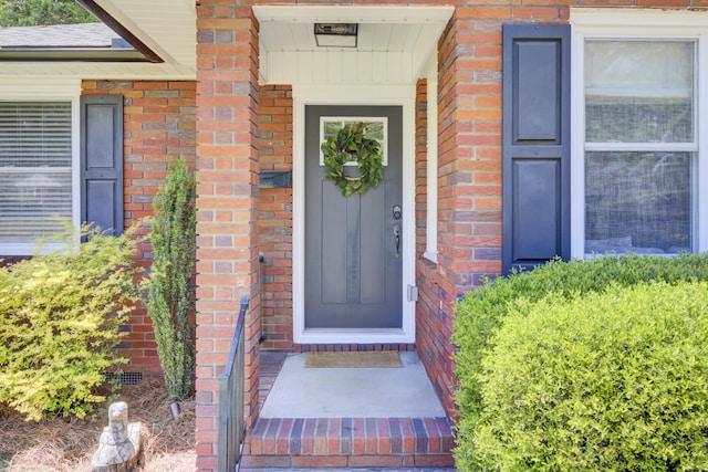 doorway to property with brick siding