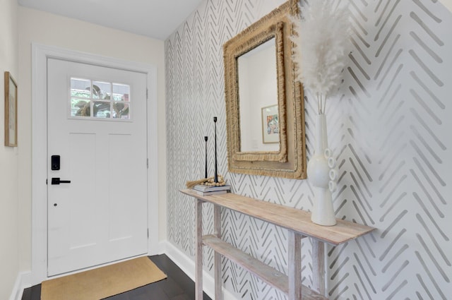 entrance foyer featuring baseboards, dark wood-type flooring, and wallpapered walls