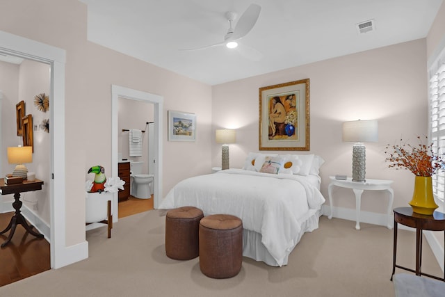 bedroom with ensuite bathroom, ceiling fan, and light colored carpet