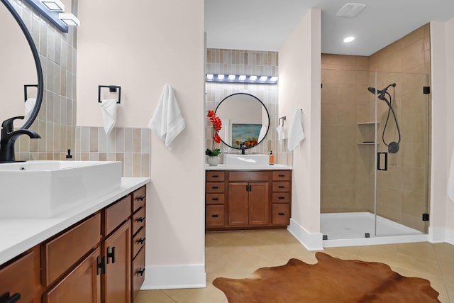 bathroom featuring tile patterned floors, vanity, decorative backsplash, and a shower with shower door