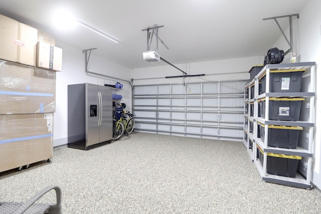 garage featuring stainless steel fridge with ice dispenser and a garage door opener