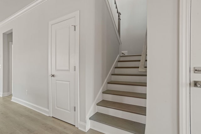 stairs with ornamental molding, hardwood / wood-style floors, and a barn door