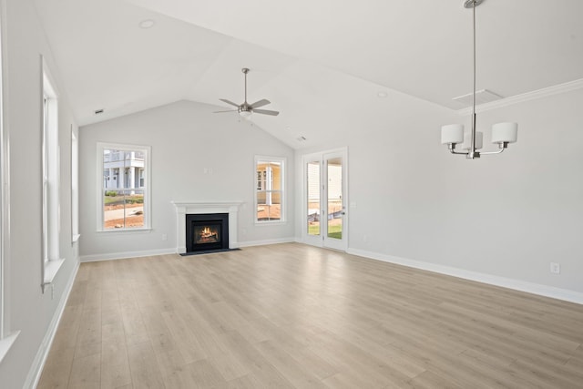 unfurnished living room with ceiling fan with notable chandelier, light hardwood / wood-style floors, and vaulted ceiling