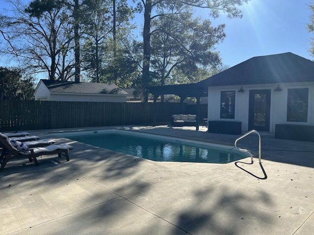 view of pool with a fenced in pool, an outbuilding, a patio, a fenced backyard, and a storage structure